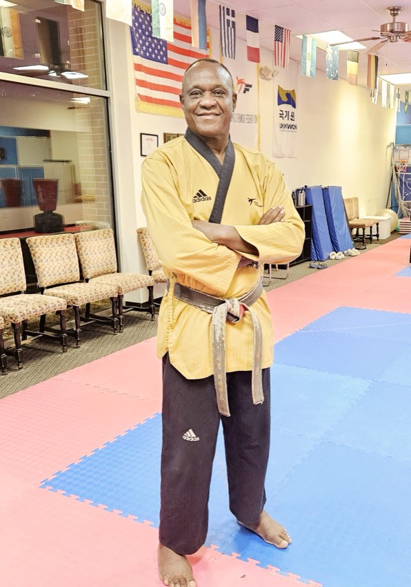 GrandMaster Pius Ilukhor, 8th-dan Taekwondo and founder of Master Pius Martial Arts, standing on the dojo floor