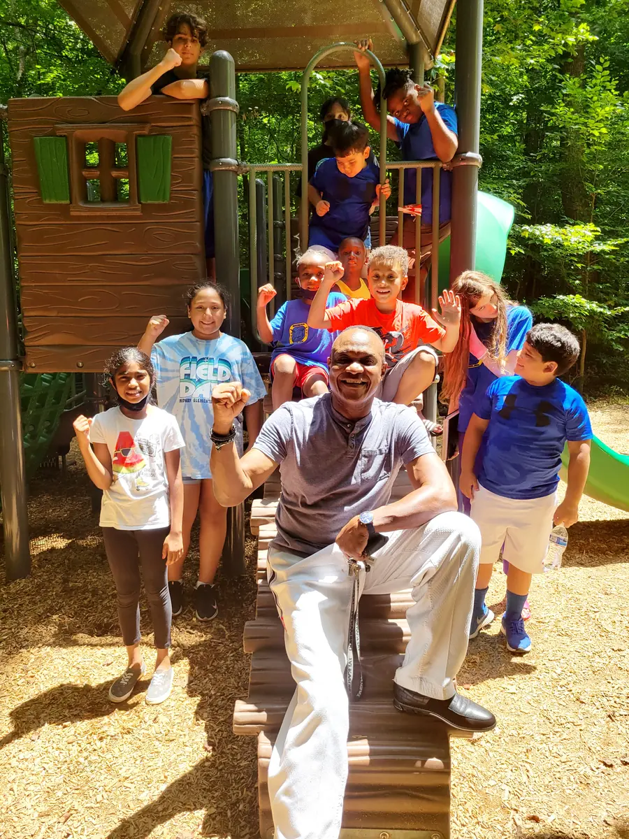 Kids and GrandMaster Pius celebrating together outdoors at Master Pius Martial Arts summer camp